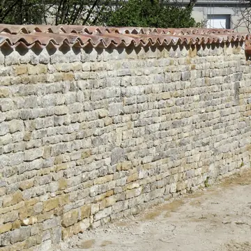 Mur en pierre avec couronnement restauré par BMH Rénovation