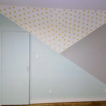 Mur intérieur peint avec motifs géométriques et détails dorés par BMH Rénovation